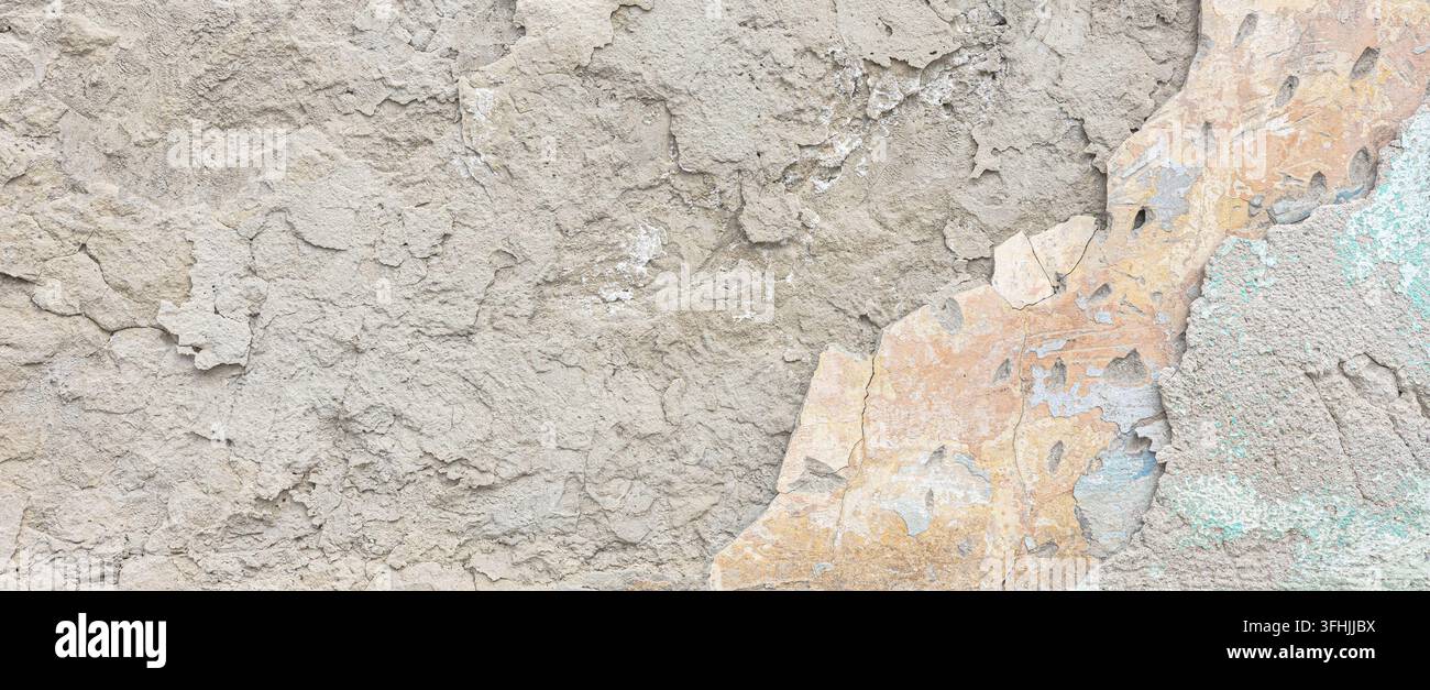 Raue Betonwand mit rissiger Oberfläche und freiliegenden Farbschichten Stockfoto