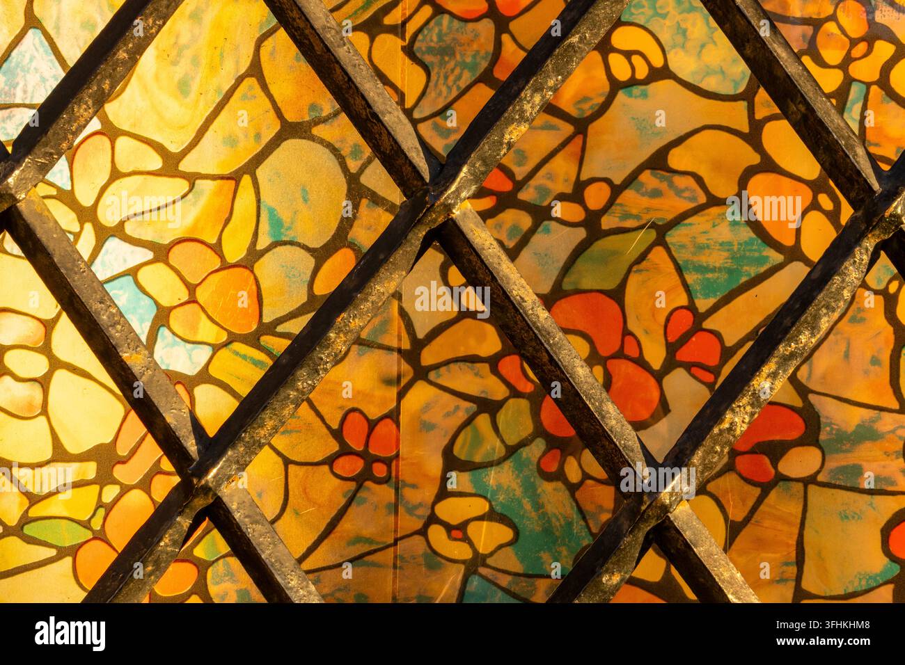 Ein Fragment eines Jugendstil-Fensters mit floralem Motiv, das von einem Bleirahmen zusammengehalten wird. Stockfoto