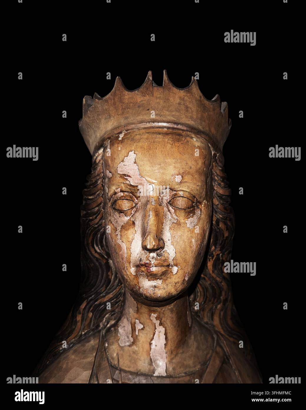 Spätgotischer hölzerner geschnitzter Büste einer Heiligen mit Krone, isoliert auf schwarzem Hintergrund Stockfoto