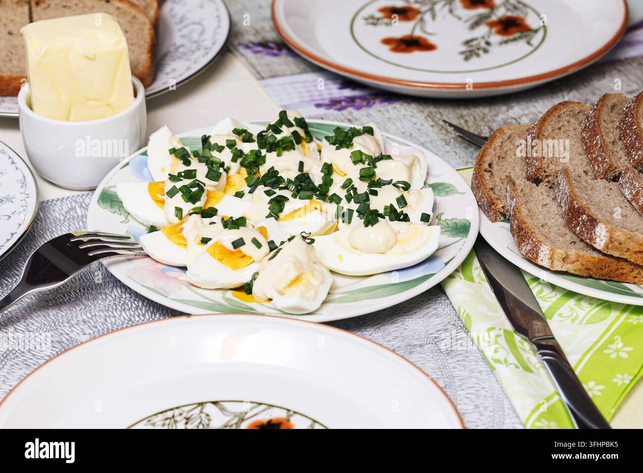 Geschnittene hartgekochte Eier mit frischem Schnittlauch auf einem Teller. Nahrungsmittelhintergrund für Frühstück gesunde Mahlzeit Proteinernährung hausgemachte Küche und einfache Gerichte. Stockfoto