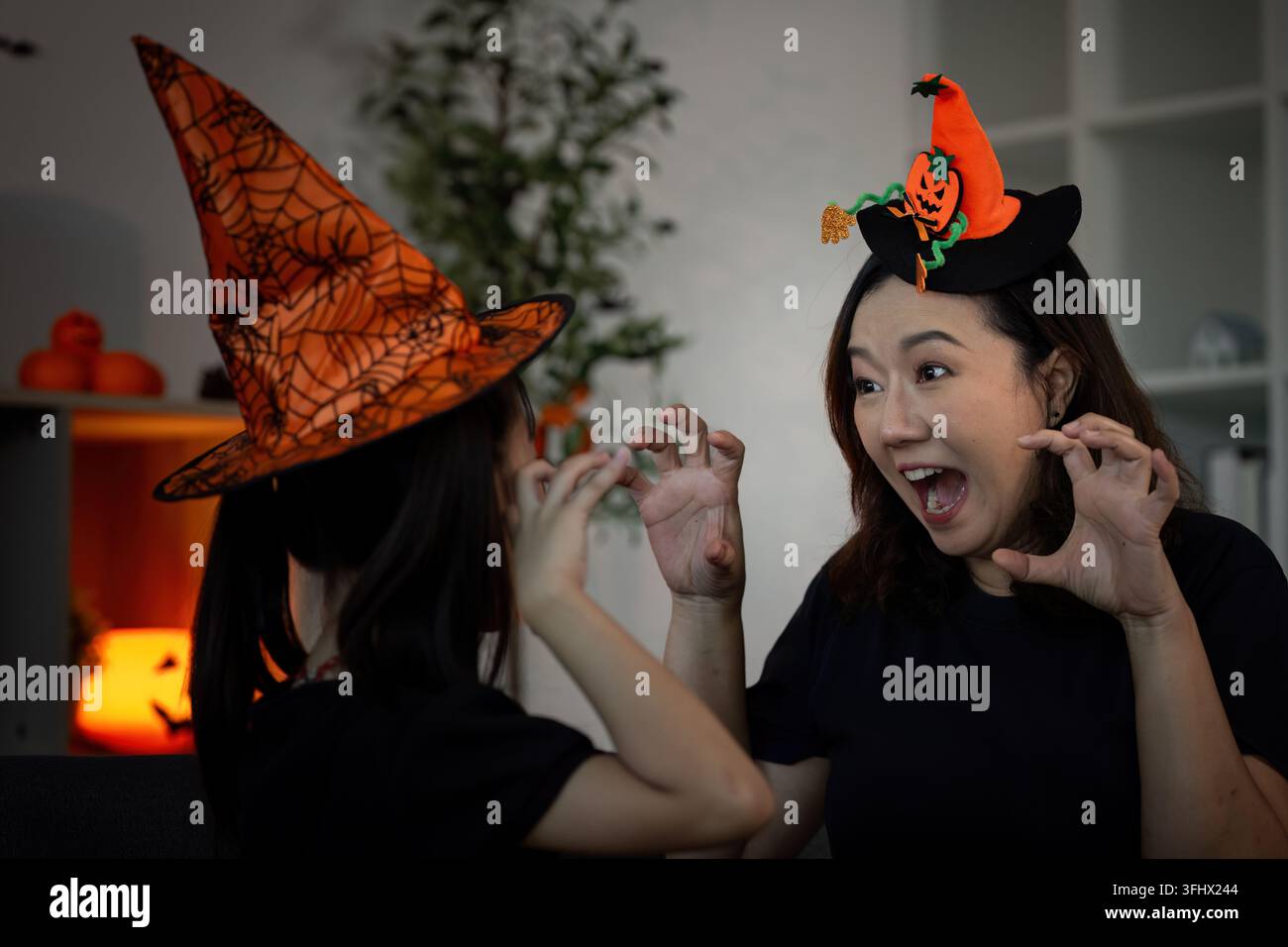 Halloween Spirit. Mutter und Tochter teilen einen verspielten Moment in gruseligen Kostümen. Stockfoto