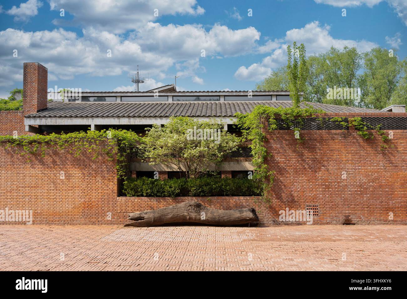 Rote Backsteinwände des Red Brick Art Museum in Peking, Innenhof unter blauem Himmel mit weißen Wolken Stockfoto