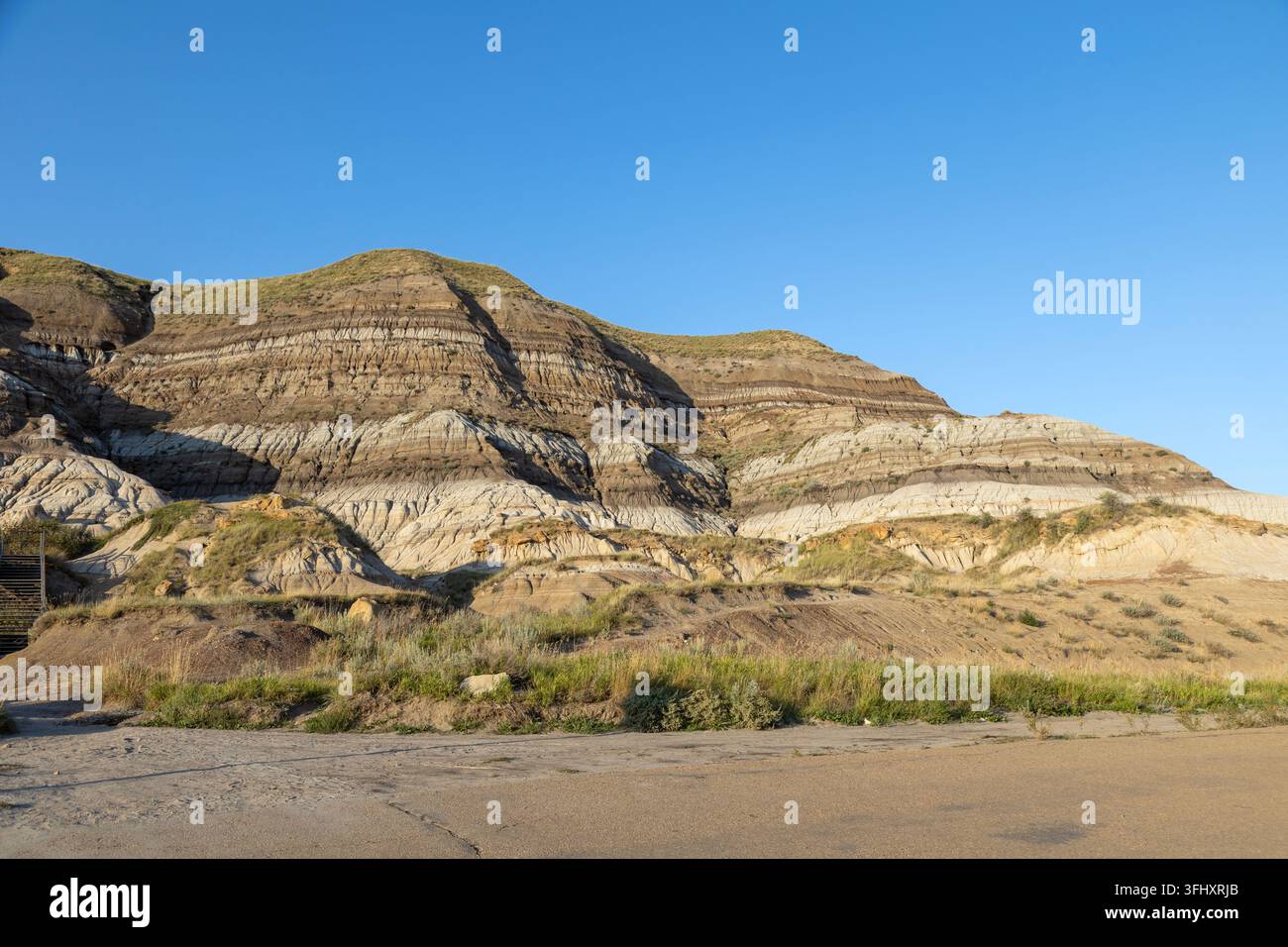 Pittoreske Wüstenlandschaft mit geschichteten Felsformationen und einem klaren blauen Himmel, Drumheller, AB TOJ OYO, Alberta, Kanada Stockfoto