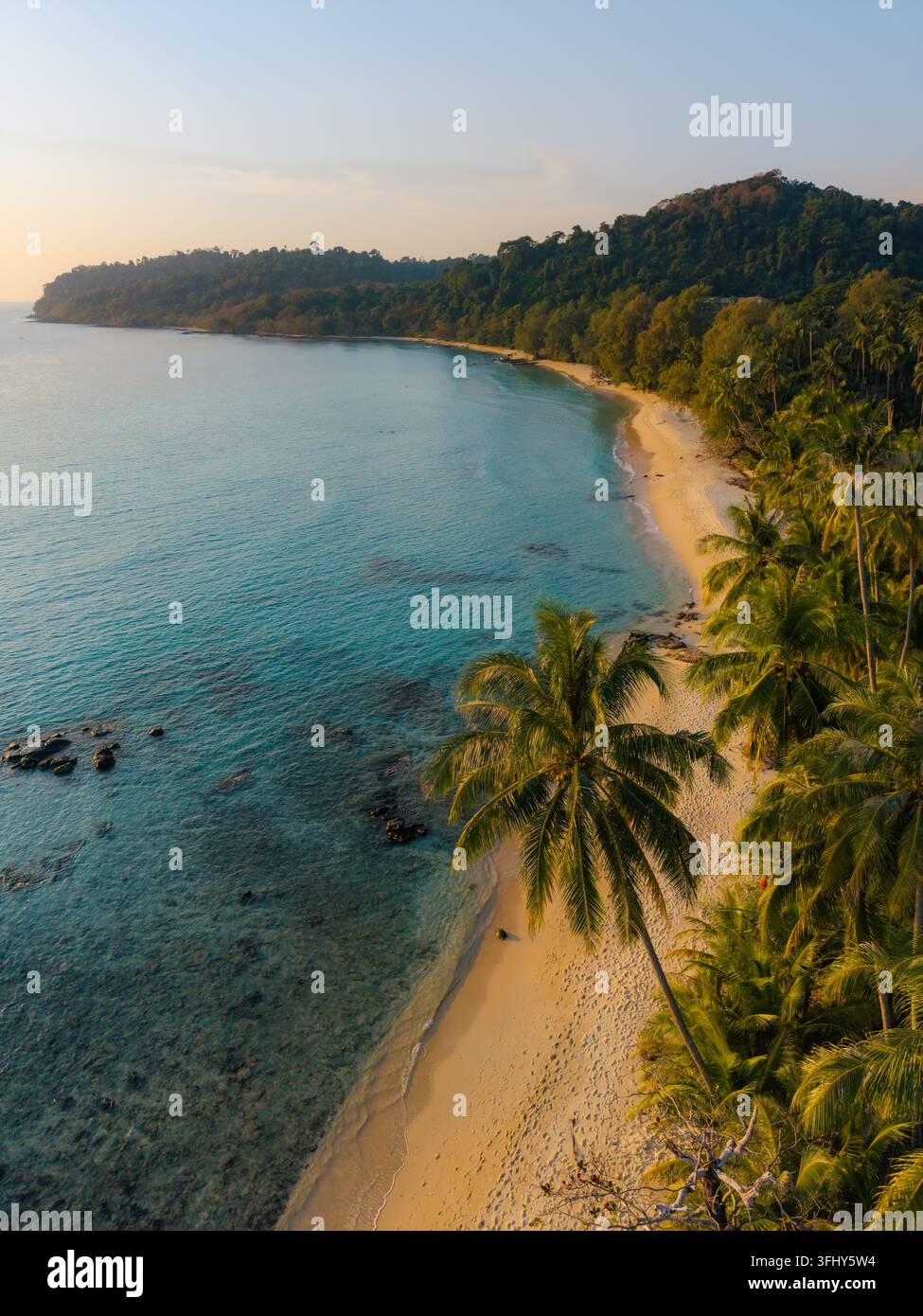 Erleben Sie die Ruhe des Takhian Beach auf Koh Kood, Thailand, während die Sonne über dem ruhigen Wasser untergeht und eine malerische Szene schafft. Stockfoto