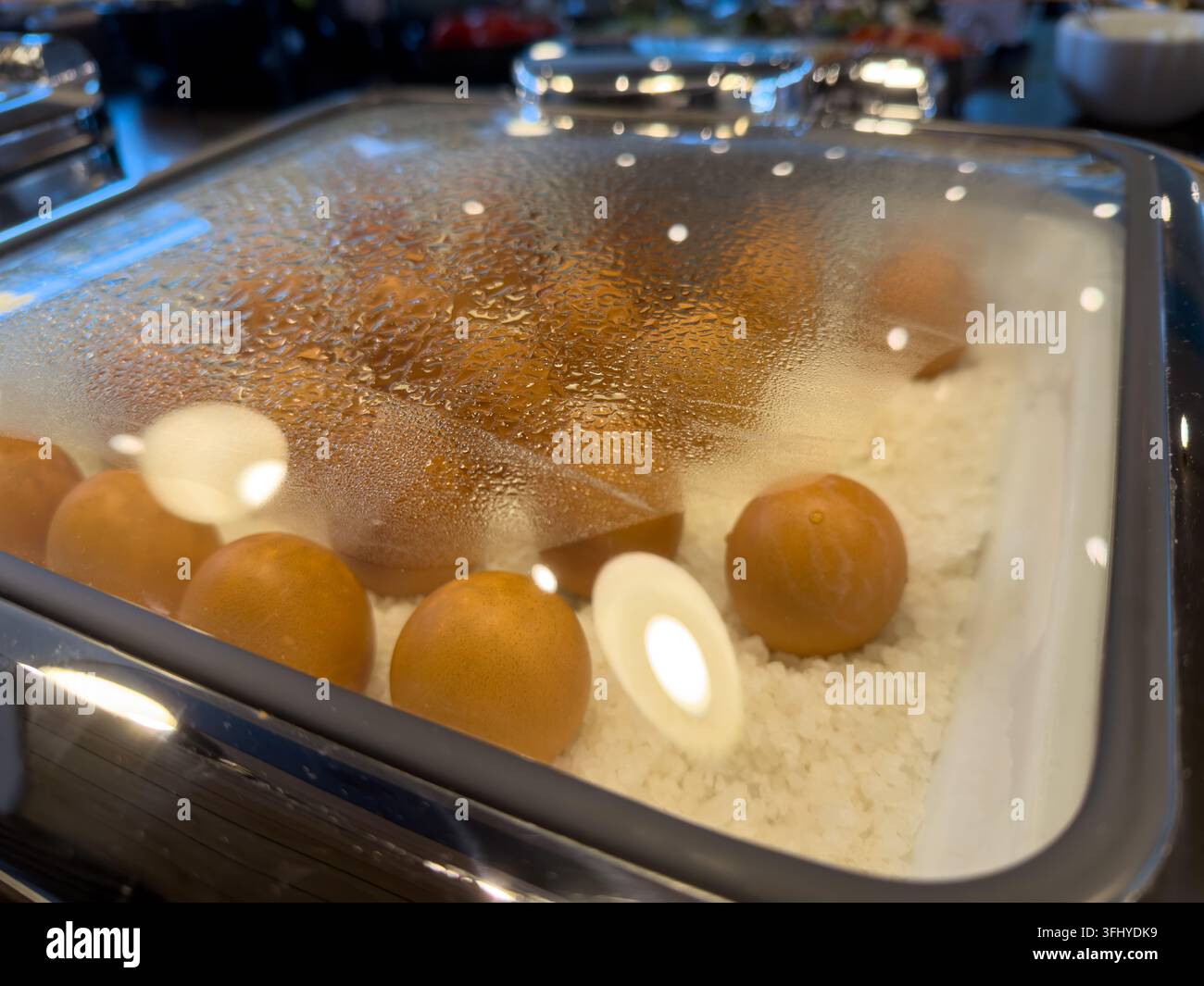 Gedämpfte braune Eier ruhen in einer beheizten Vitrine an einer morgendlichen Catering-Station, um heiße Servicestandards für Reisende zu gewährleisten, die eine nahrhafte Mahlzeit genießen Stockfoto