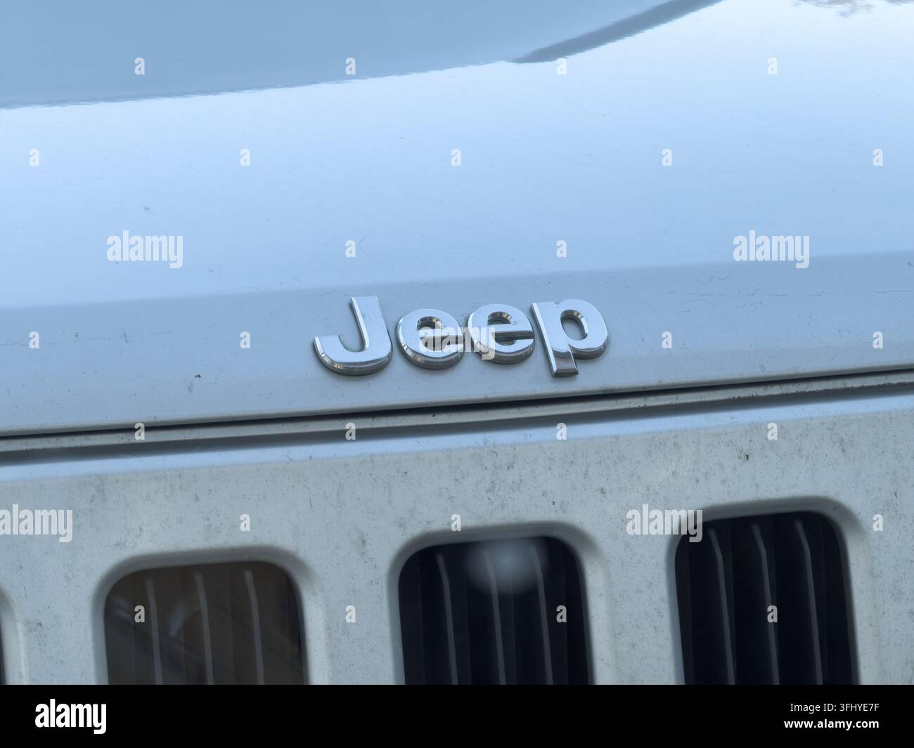 Szklarska Poręba, Polen – 17. Dezember 2025: Jeep-Logo auf einer glänzenden weißen Motorhaube eines Autos, das das ikonische Metallabzeichen eines robusten Fahrzeugs zeigt Stockfoto