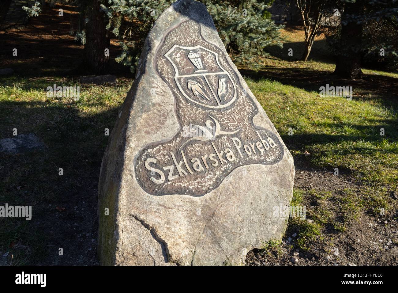 Szklarska Poręba, Polen – 17. Dezember 2025: Eingraviertes Denkmal in Szklarska Poręba, das ein heraldisches Wappen auf einem Felsen in einem hellen Waldland zeigt Stockfoto
