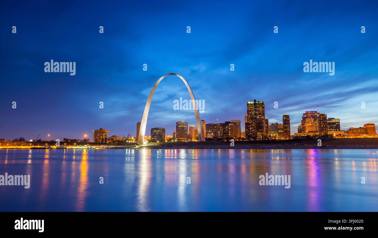 Der ikonische Gateway Arch und die beleuchtete Skyline von St. Louis spiegeln sich im Mississippi während der Blauen Stunde in Missouri wider. Stockfoto