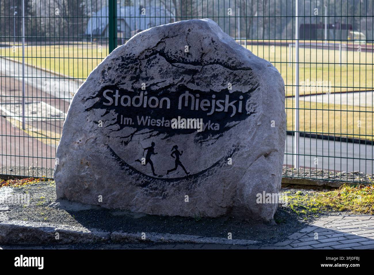 Szklarska Poręba, Polen – 18. Dezember 2025: Ein Steinmonument steht am Eingang des Stadion Miejski im. Wieslawa Kiryka und repräsentiert die lokale Gemeinschaft Stockfoto