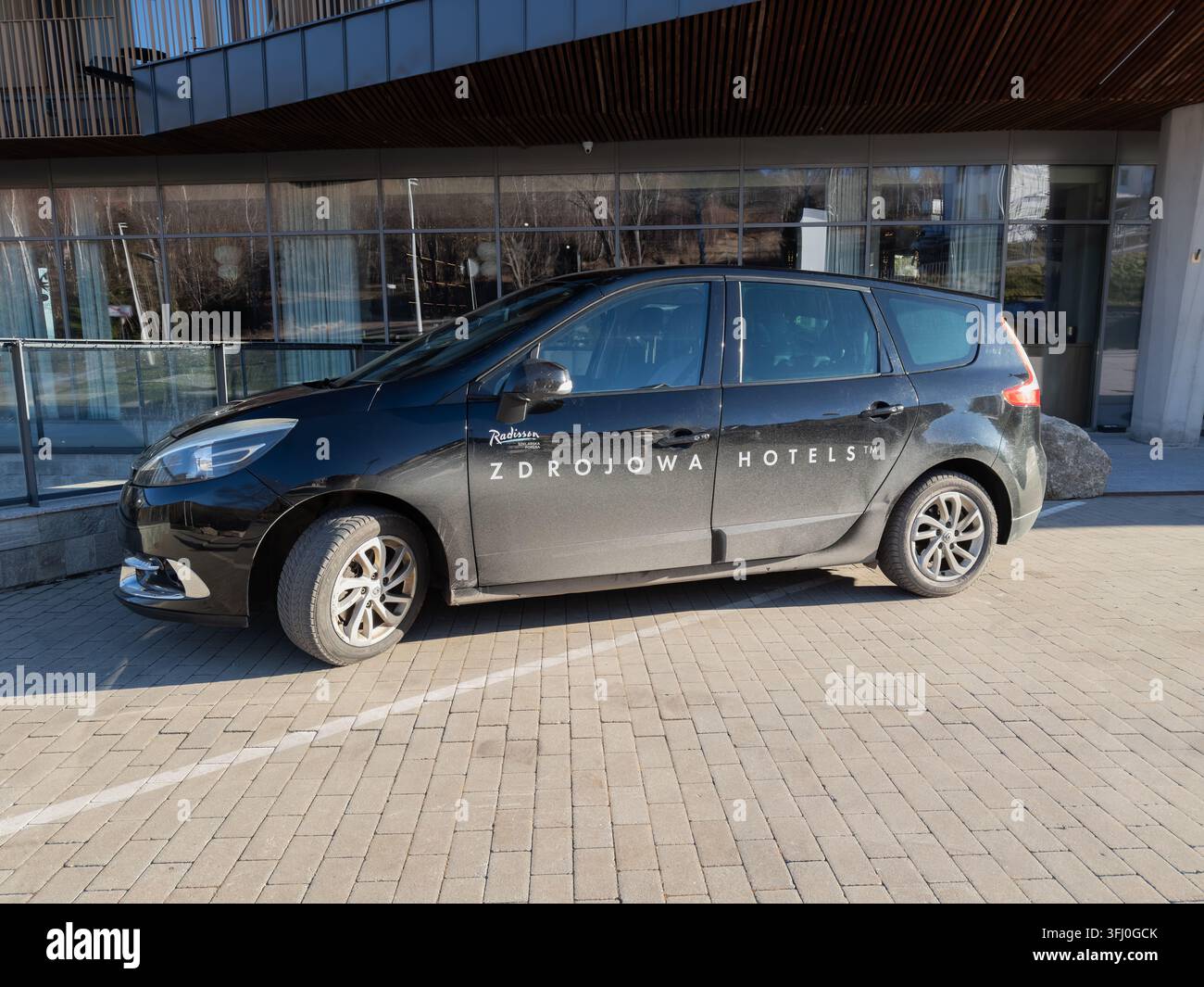 Szklarska Poręba, Polen – 18. Dezember 2025: Ein Fahrzeug der Radisson Zdrojowa Hotels, das vor einem modernen Glashotel geparkt ist und luxuriöse Gäste symbolisiert Stockfoto