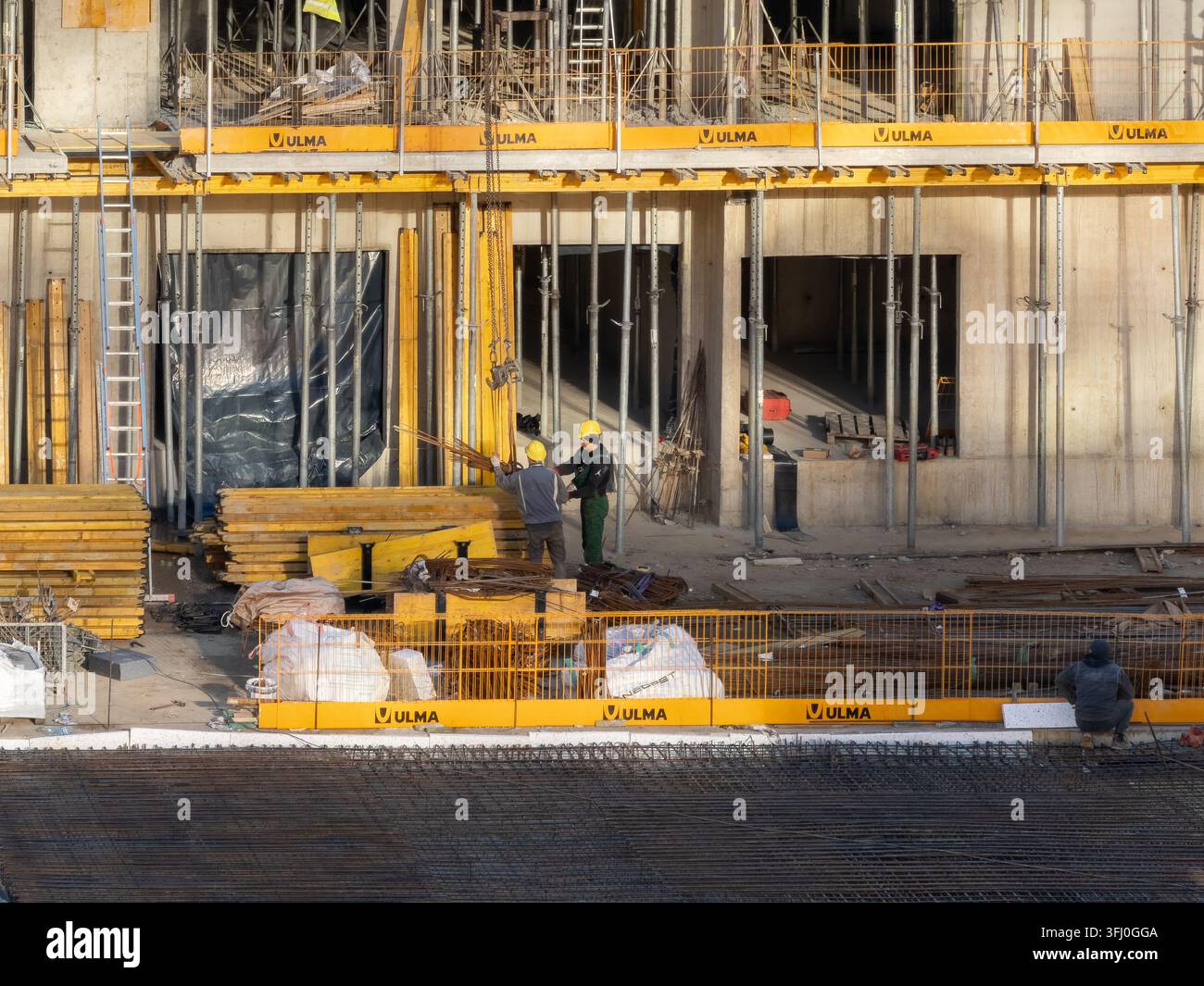 Szklarska Poręba, Polen - 18. Dezember 2025: Ulma-Industriegerüste und Schalungssysteme unterstützen Arbeiter, die mit Stahlrosten an einem modernen b arbeiten Stockfoto