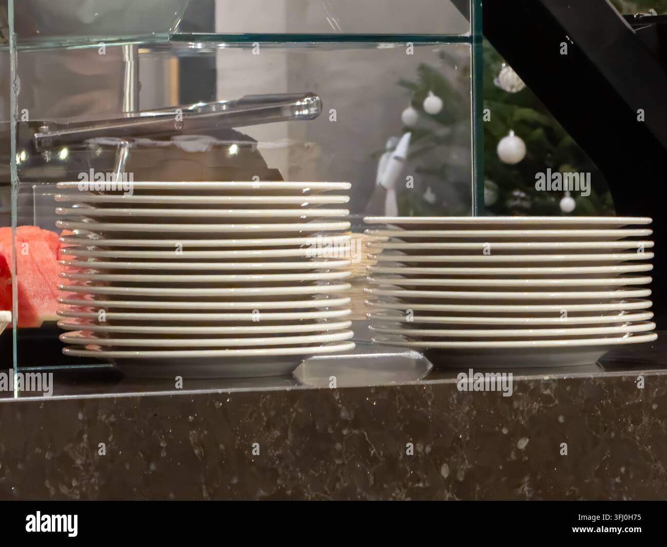 Saubere Keramikgeschirre in Reihen auf einer glatten Oberfläche während eines festlichen Catering-Services, die effiziente Organisation und Vorbereitung für die Gaststätte hervorheben Stockfoto