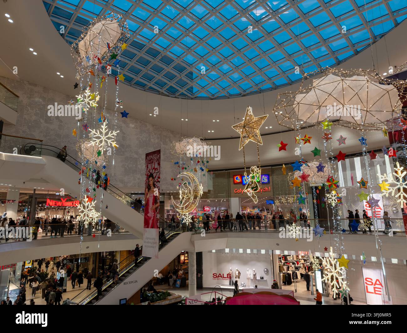 Wroclaw, Polen – 9. Dezember 2025: Eine aparte dekorative Lichtinstallation hängt in einem belebten Gewerbezentrum und zeigt saisonale Ornamente, die hell Stockfoto