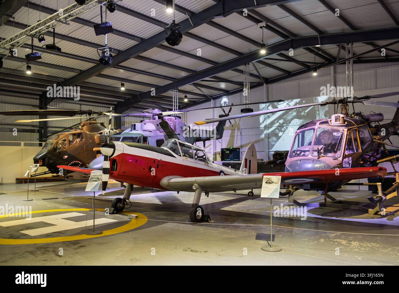 Ein erhaltenes de Havilland Chipmunk-Schulflugzeug neben einem Westland Scout, Lynx und Bell Cobra-Hubschrauber im Army Flying Museum, UK Stockfoto
