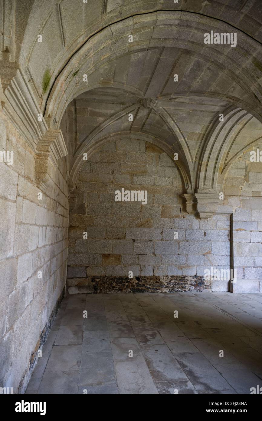 Steinerne Kreuzrippengewölbe und Bögen im historischen Kreuzgang des Klosters Santa María de Sobrado. Stockfoto