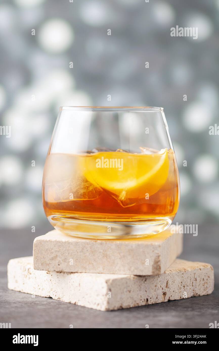 Glas Whiskey mit Zitrone und Eis auf Steinhintergrund. Stockfoto
