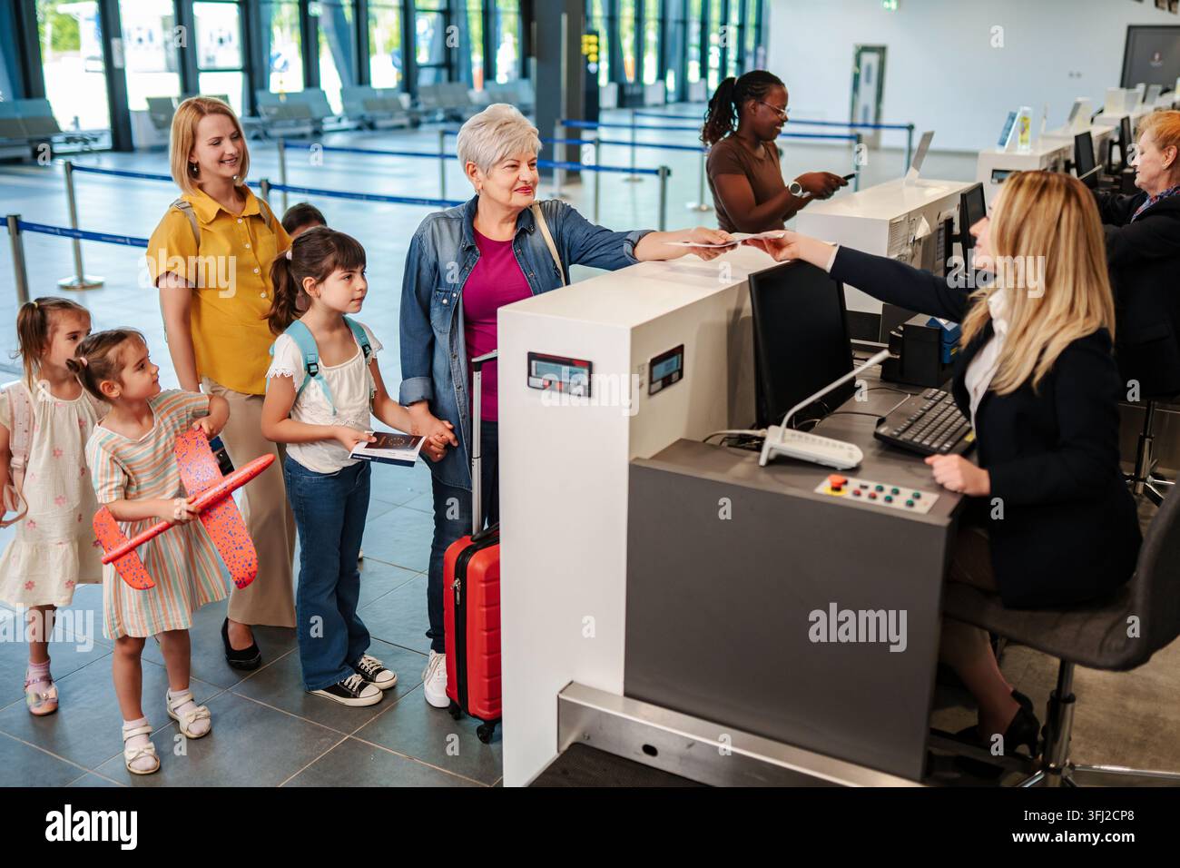 Familien mit mehreren Generationen, die am Flughafen für Urlaub einchecken Stockfoto