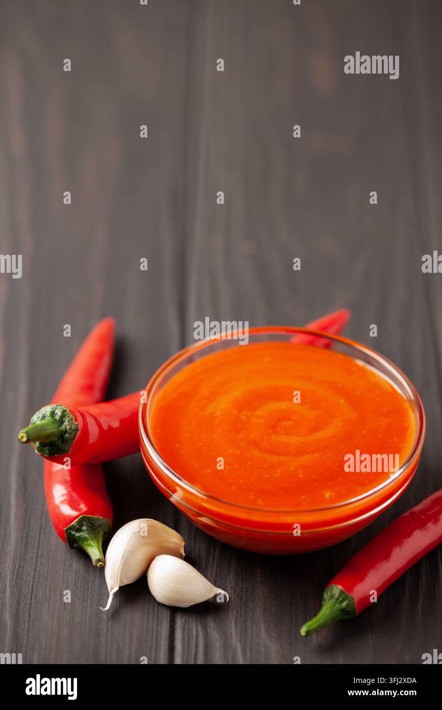 Frische Sriracha-Chili-Sauce in einer Schüssel auf Holzunterlage. Stockfoto