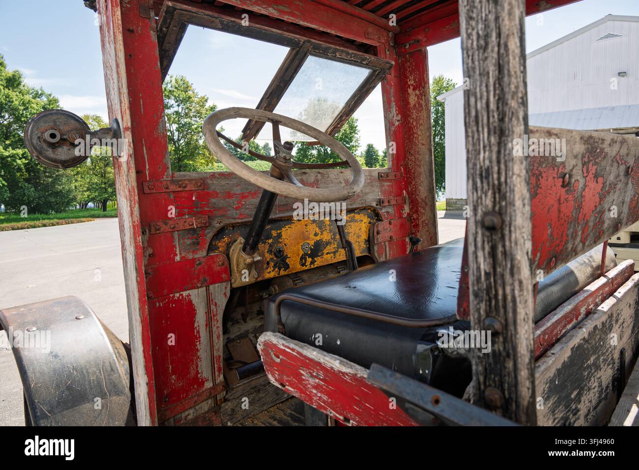 Interieur eines antiken Bauernhof-Trucks mit Handbremse und Holzlenkrad Stockfoto