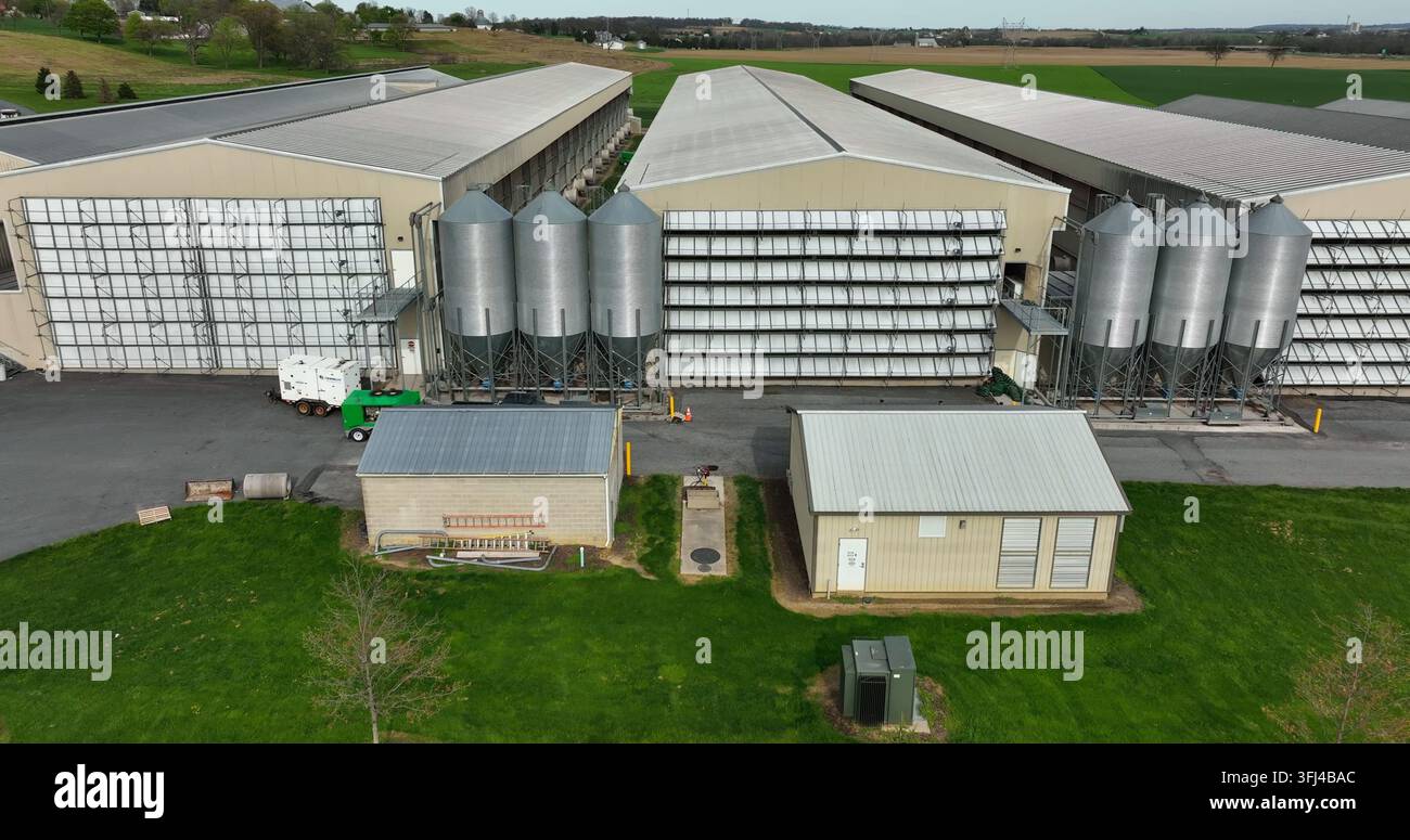 Große Scheunen für Hennen und Hühner. Eierlegebetrieb auf einer Massentierhaltungsfarm in den USA. Aus der Luft sind Behälter mit Hühnerfutter zu sehen, East Donegal Township, Pen Stockfoto