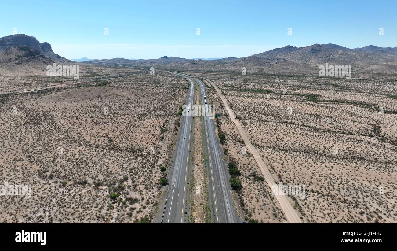 Luftaufnahme, die sich erhebt und eine Autobahn zeigt, die sich durch die weite Wüste im Südwesten der USA, Cochise County, Arizona, schneidet Stockfoto