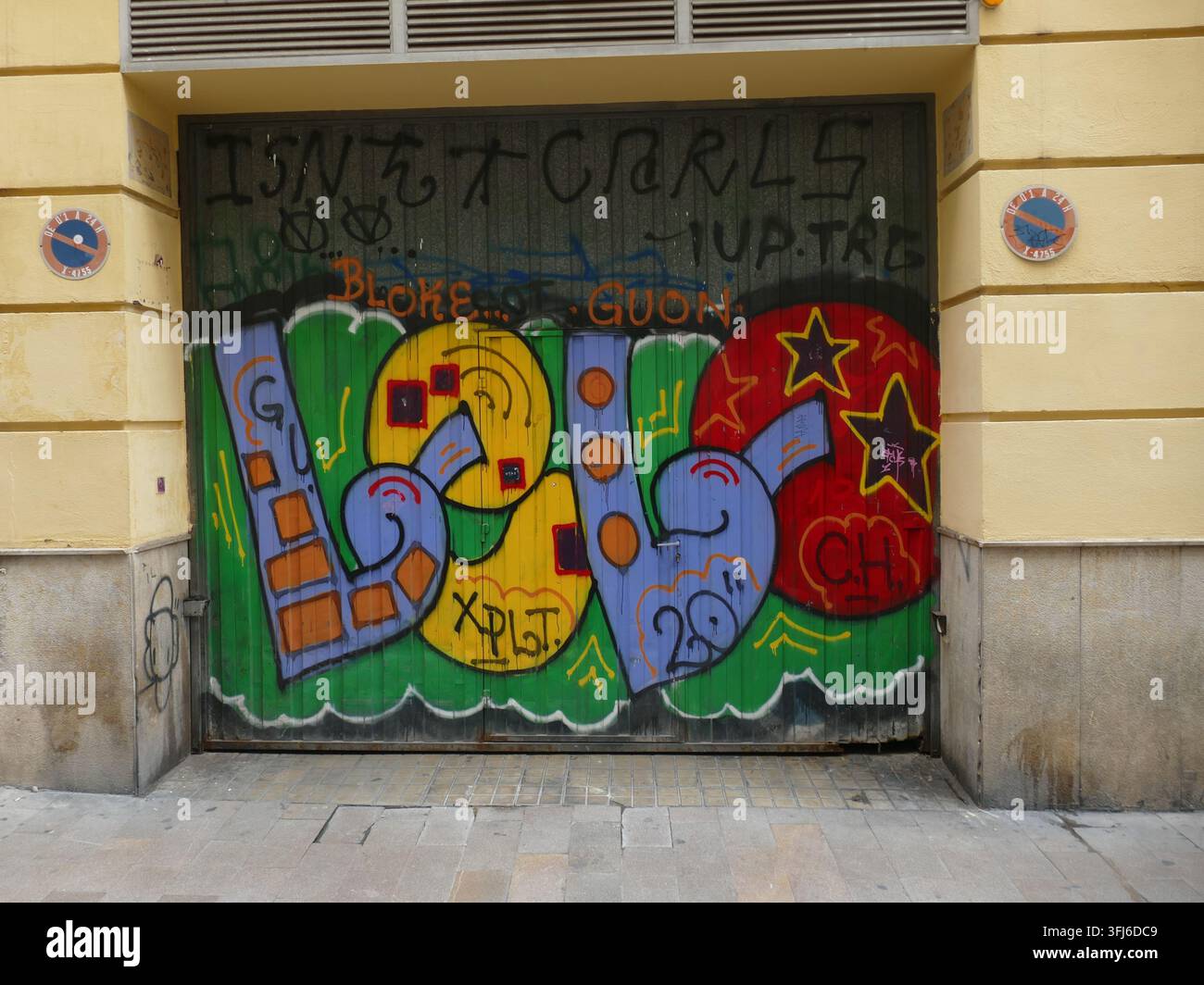 VALENCIA, SPANIEN - 21. OKT. 2025 - Graffitimalerei, die den Eingang eines Gebäudes schmückt, mit kräftigen Farben und urbaner Straßenkunst, die eine lebendige v Stockfoto