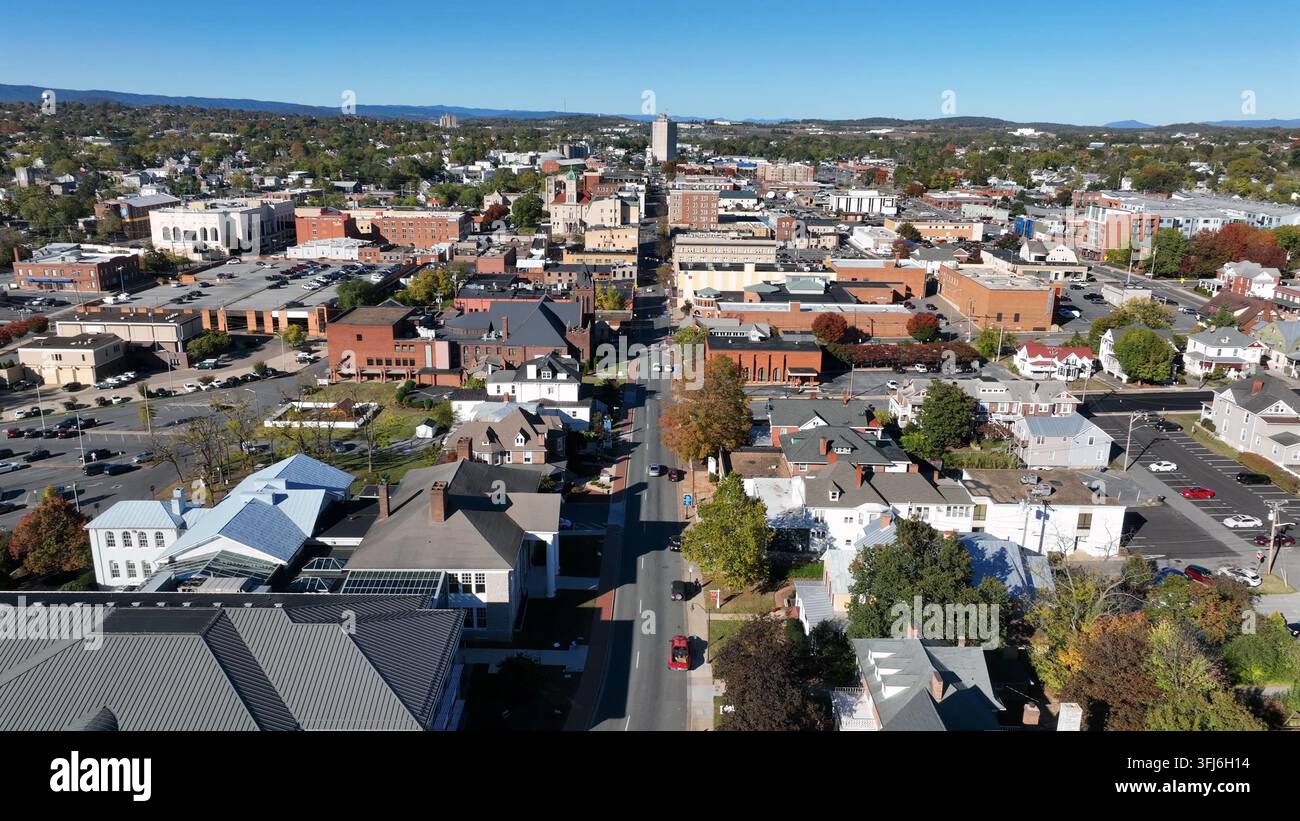 Dronenflug über die Main Street von Harrisonburg Downtown, Virginia. Sonniger Tag mit historischen Gebäuden in der Innenstadt. Farbige Bäume an einem schönen Tag im Herbst Stockfoto