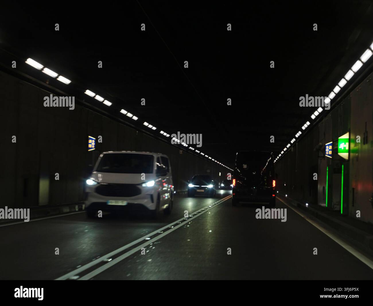 Der Verkehr im Gotthard-Tunnel fließt in der Nacht Stockfoto