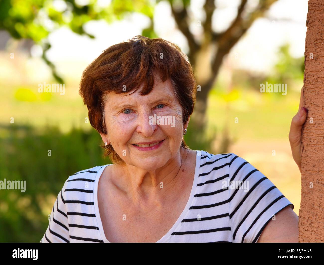 Porträt einer lächelnden Seniorin im Freien im Sommer. - Smartphone-aufgenommenes Stockfoto