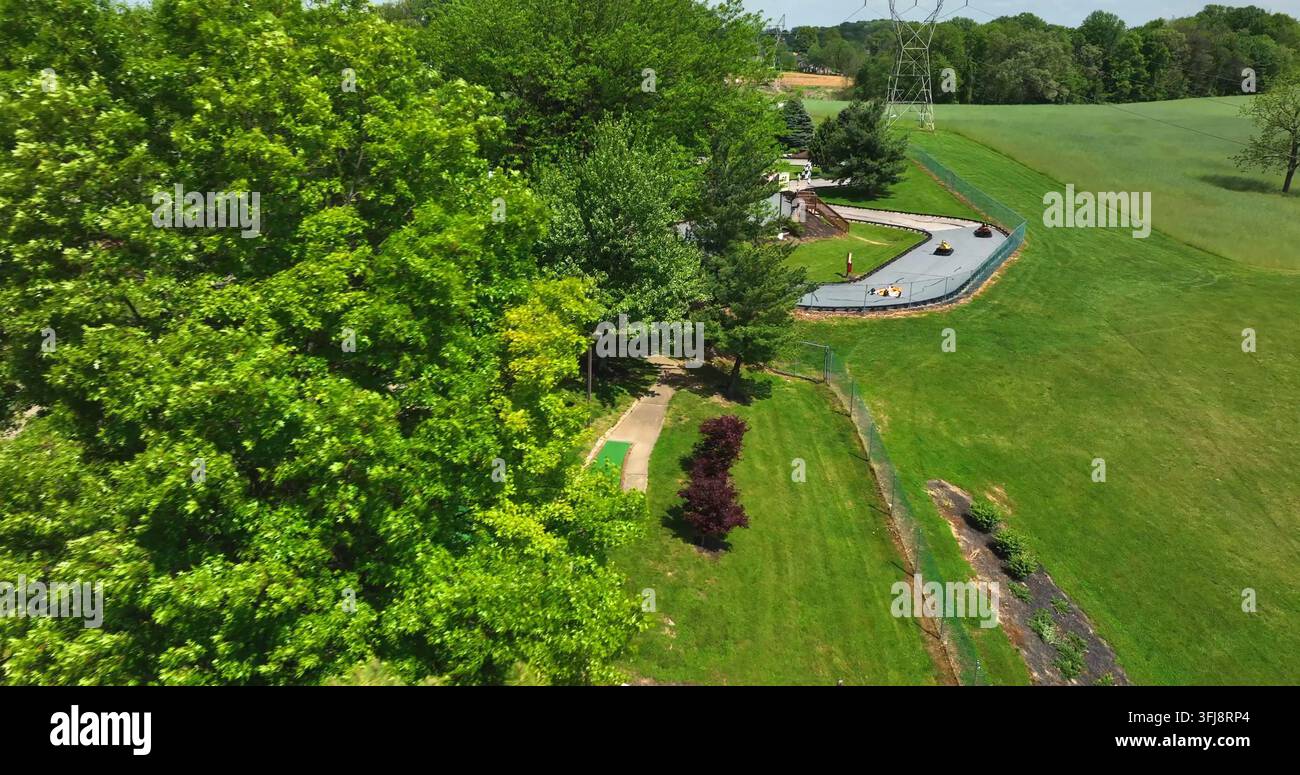 Luftaufnahme eines Minigolfplatzes an einem schönen Frühlingstag. Bäume zeigen Go-Karts, die auf einer kleinen Strecke rasen. Amerikanische Freizeitaktivitäten, Warwick Township, P Stockfoto