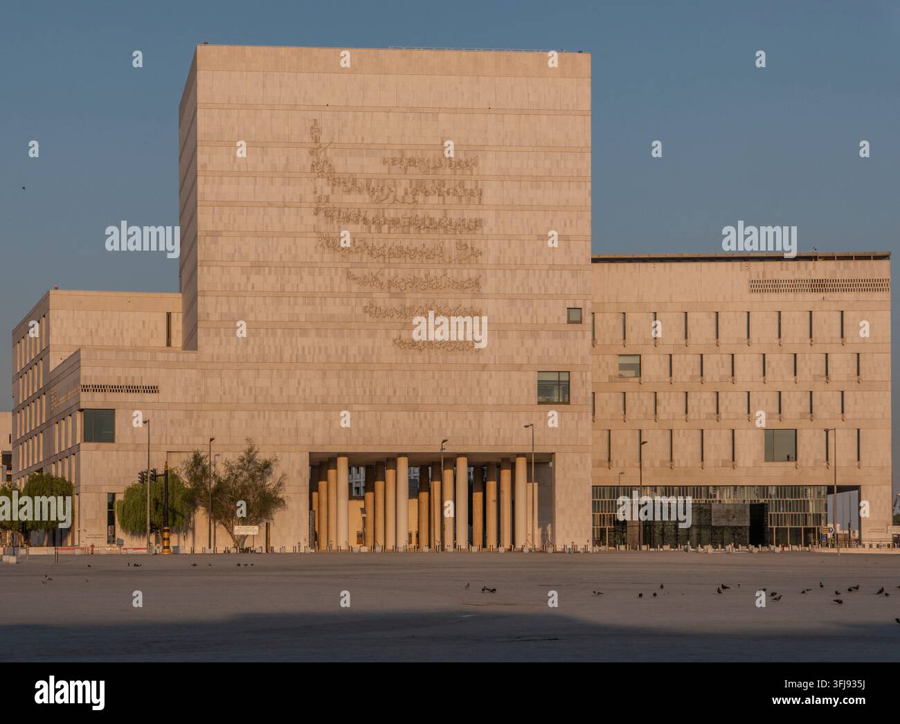 Außenansicht des Qatar National Archive-Gebäudes mit einer Fassade aus arabischer Kalligrafie, steinerner Kolonnade und modernem architektonischem Design in Doha. Stockfoto