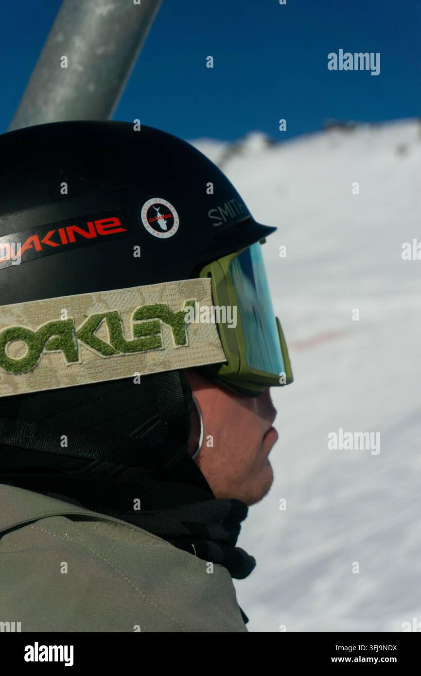 Nahaufnahme des Seitenprofils eines Snowboarders, der einen Skihelm und verspiegelte Schutzbrille trägt, im Skigebiet Val Thorens, Drei Täler, Französische Alpen, Frankreich. Stockfoto