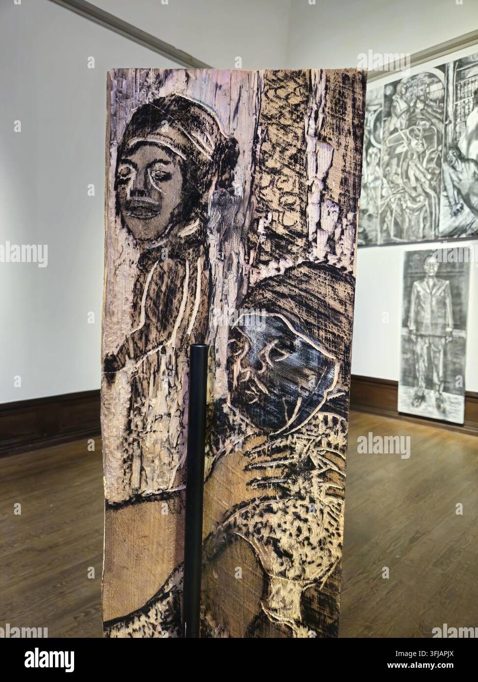 Stockholm, Schweden, 11. Januar 2026. Detailliert geschnitztes Holzpaneel mit zwei ausdrucksstarken Porträtfiguren, präsentiert in einer zeitgenössischen Kunstgalerie. Stockfoto
