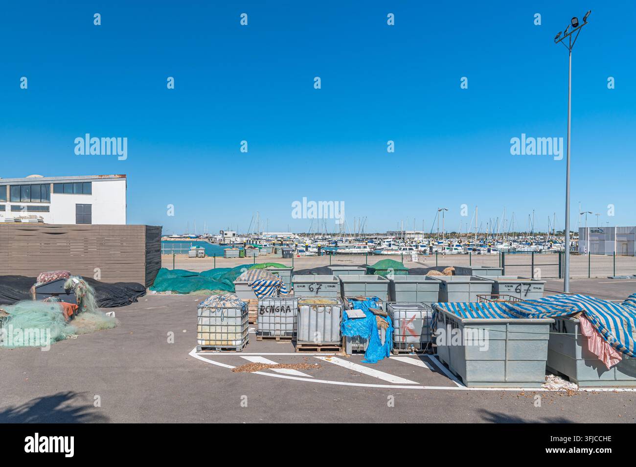 CHIPIONA, SPANIEN - 5. APRIL 2023: Blick auf den Hafen von Chipiona, Provinz Cadiz, Andalusien, Südspanien, mit Containern, die Angelausrüstung enthalten Stockfoto