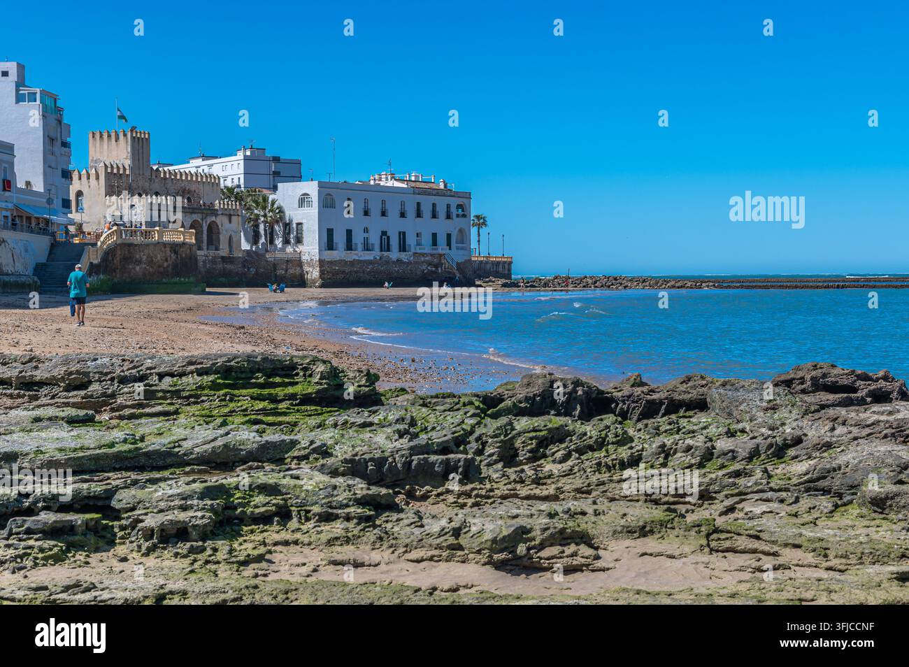 CHIPIONA, SPANIEN - 5. APRIL 2023: Blick auf die Küstenstadt Chipiona in der Provinz Cadiz, Andalusien, Spanien, mit Menschen am Sandstrand und dem Meer Stockfoto