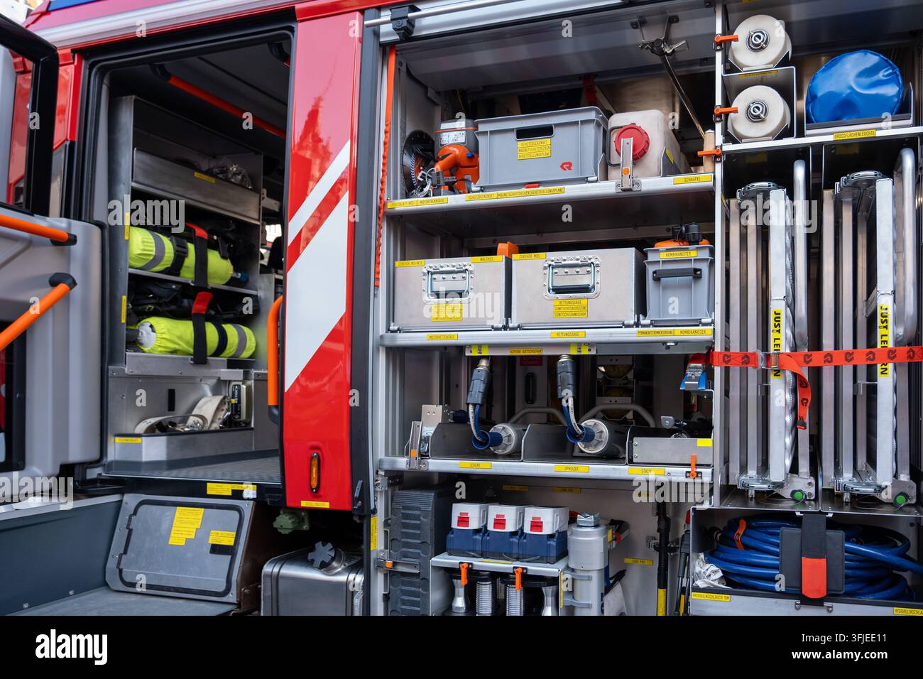 WIEN, ÖSTERREICH, 12. September 2026: Offene Fächer an einem Feuerwehrwagen zeigen organisierte Rettungsausrüstung, Schläuche und Lagerausrüstung. Stockfoto