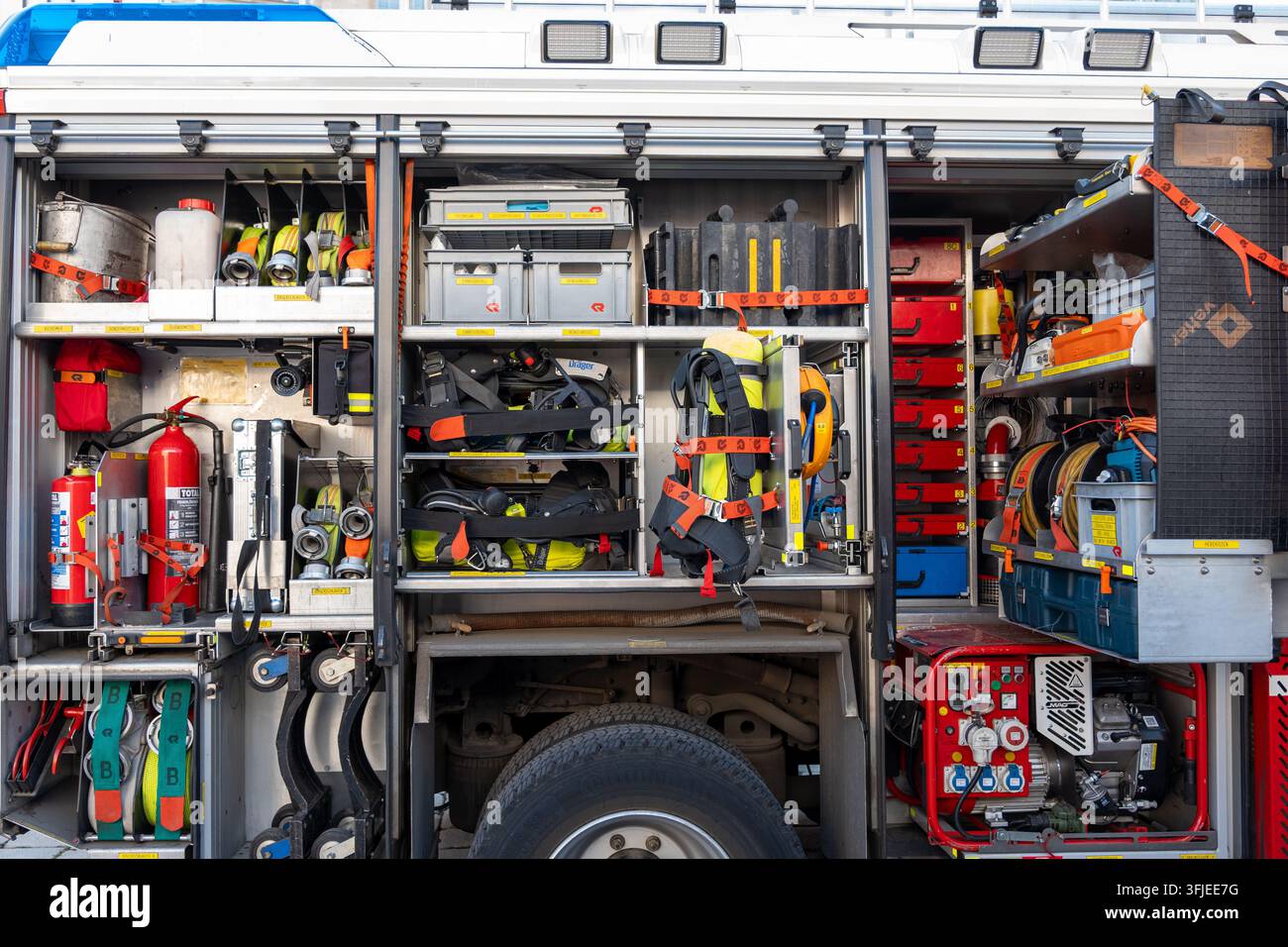 WIEN, ÖSTERREICH, 12. September 2026: Offene Seitenfächer eines Feuerwehrwagens, gefüllt mit Feuerlösch- und Rettungsausrüstung. Stockfoto