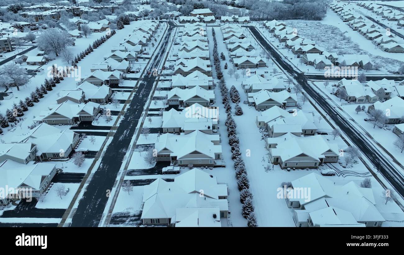 Moderne amerikanische Wohngegend, die mit frischem Schnee bedeckt ist. Symmetrische Wohnanlage und ruhige Straßen, ruhige Winteratmosphäre in den Vororten der Vereinigten Staaten Stockfoto
