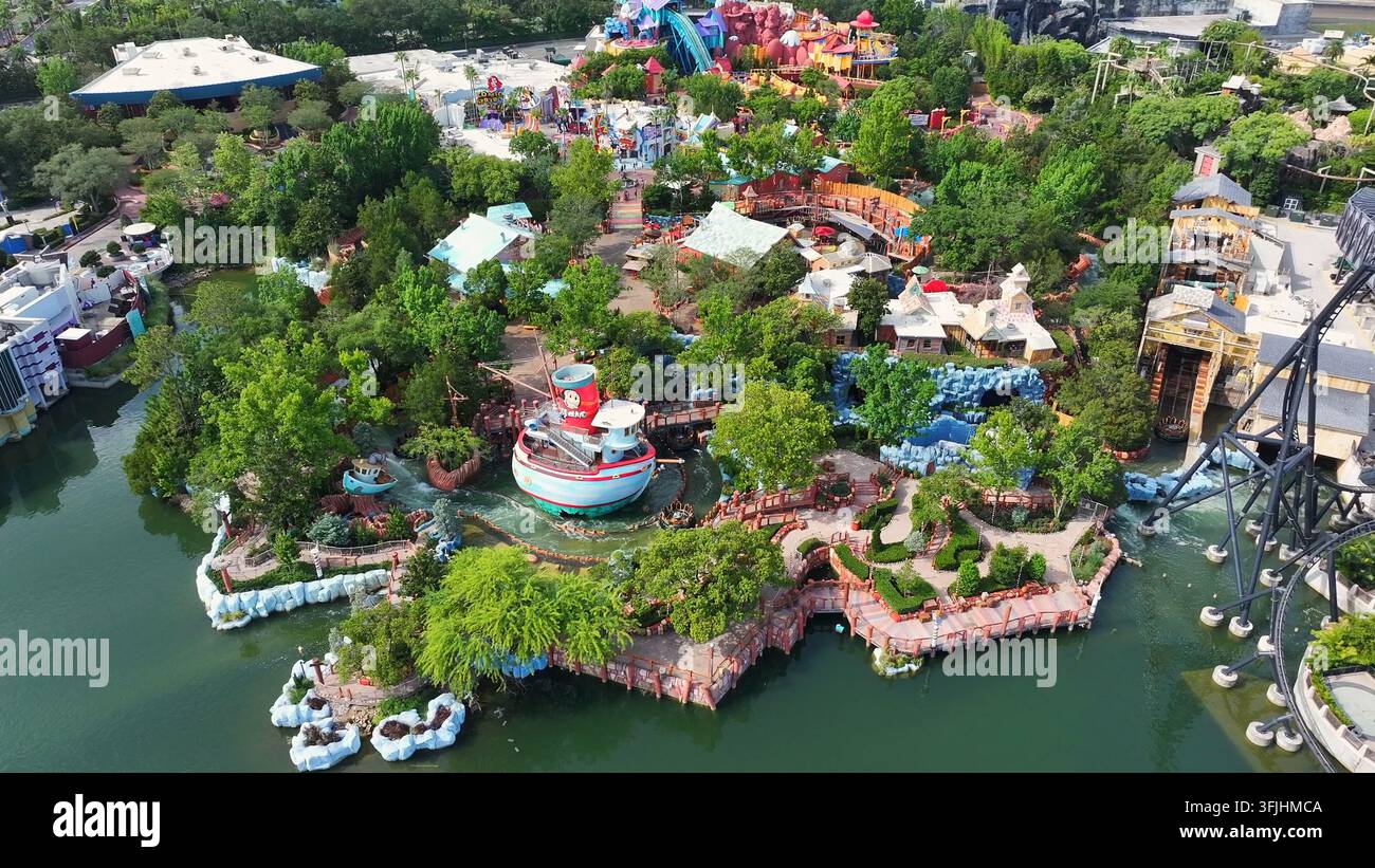 Universal Studios in Orlando mit vielen Besuchern an einem sonnigen Tag. Vergnügungspark mit Achterbahn, Booten und Fluss-Wasserpark im Themenpark. Weite Aufnahme. Stockfoto