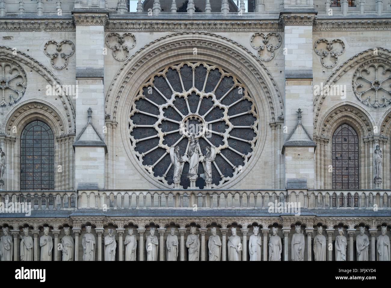 Fassade der Kathedrale Notre-Dame de Paris mit dem aufwendigen Rosenzfenster, der Statue der Jungfrau Maria mit Kind und einer Reihe von Königsskulpturen Stockfoto