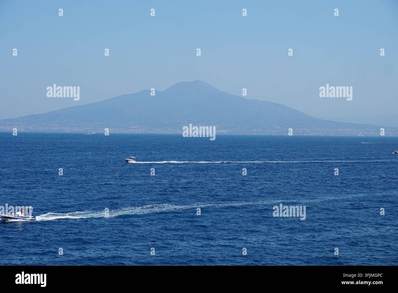 Motorboote kreuzen auf dem blauen Meer in der Nähe des Vesuvs Stockfoto