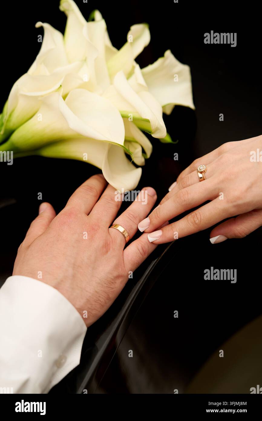 Eheringe an den Händen der Frischvermählten. Stockfoto