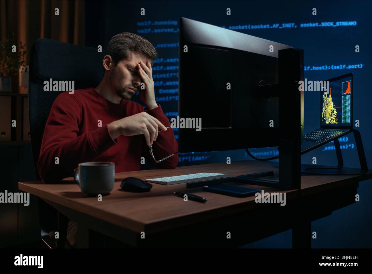 Erschöpfter Softwareingenieur, der Überstunden in einem dunklen Heimbüro macht, die Brille abnimmt und müde Augen reibt nach Stunden des Codierens vor dem Bildschirm und unter Termindruck. Stockfoto