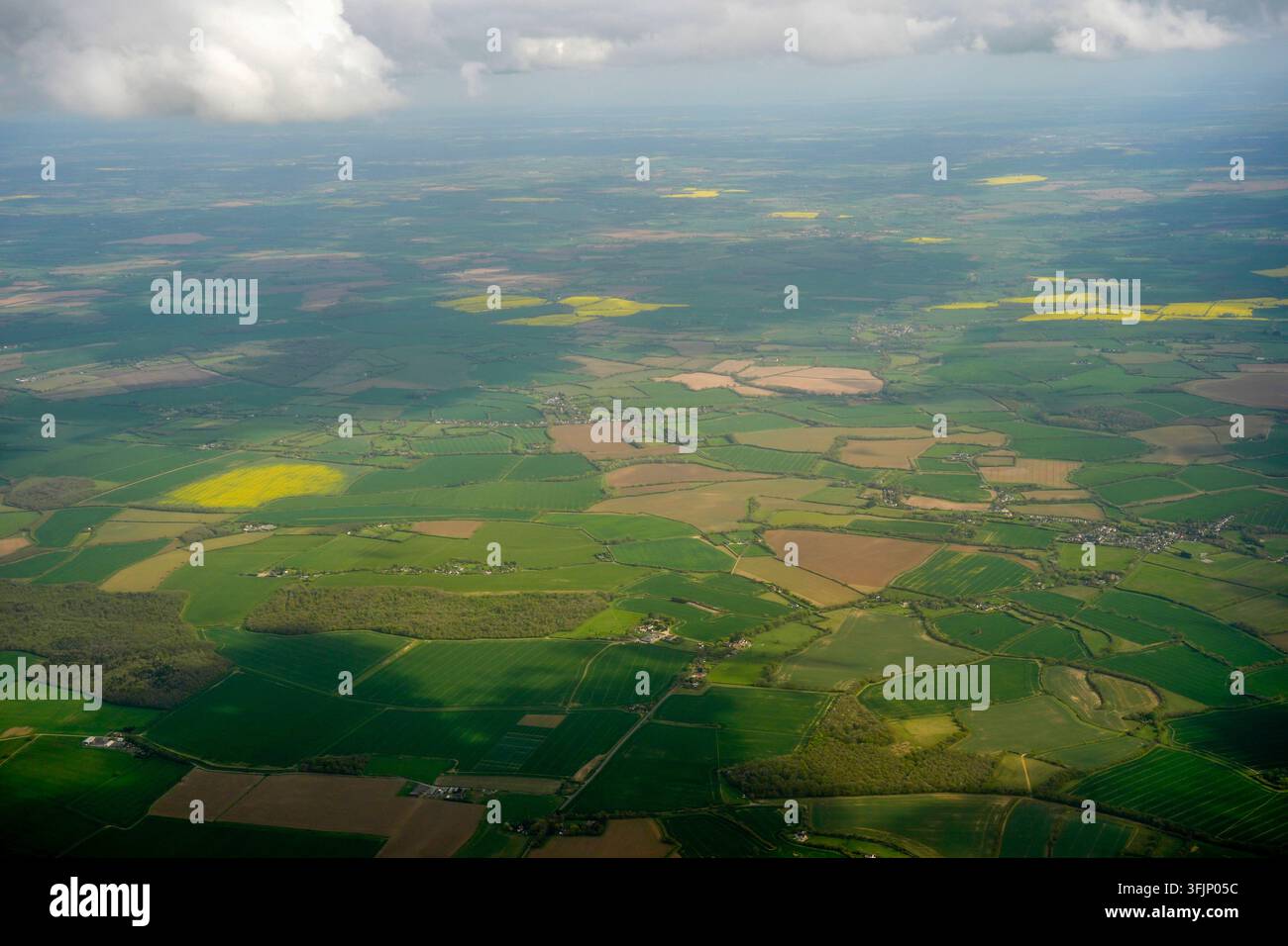 Luftbild einer üppigen grünen englischen Landschaft mit einem Mosaik aus Ackerfeldern und gelben Rapsfeldern in der Nähe von London Stansted. Stockfoto