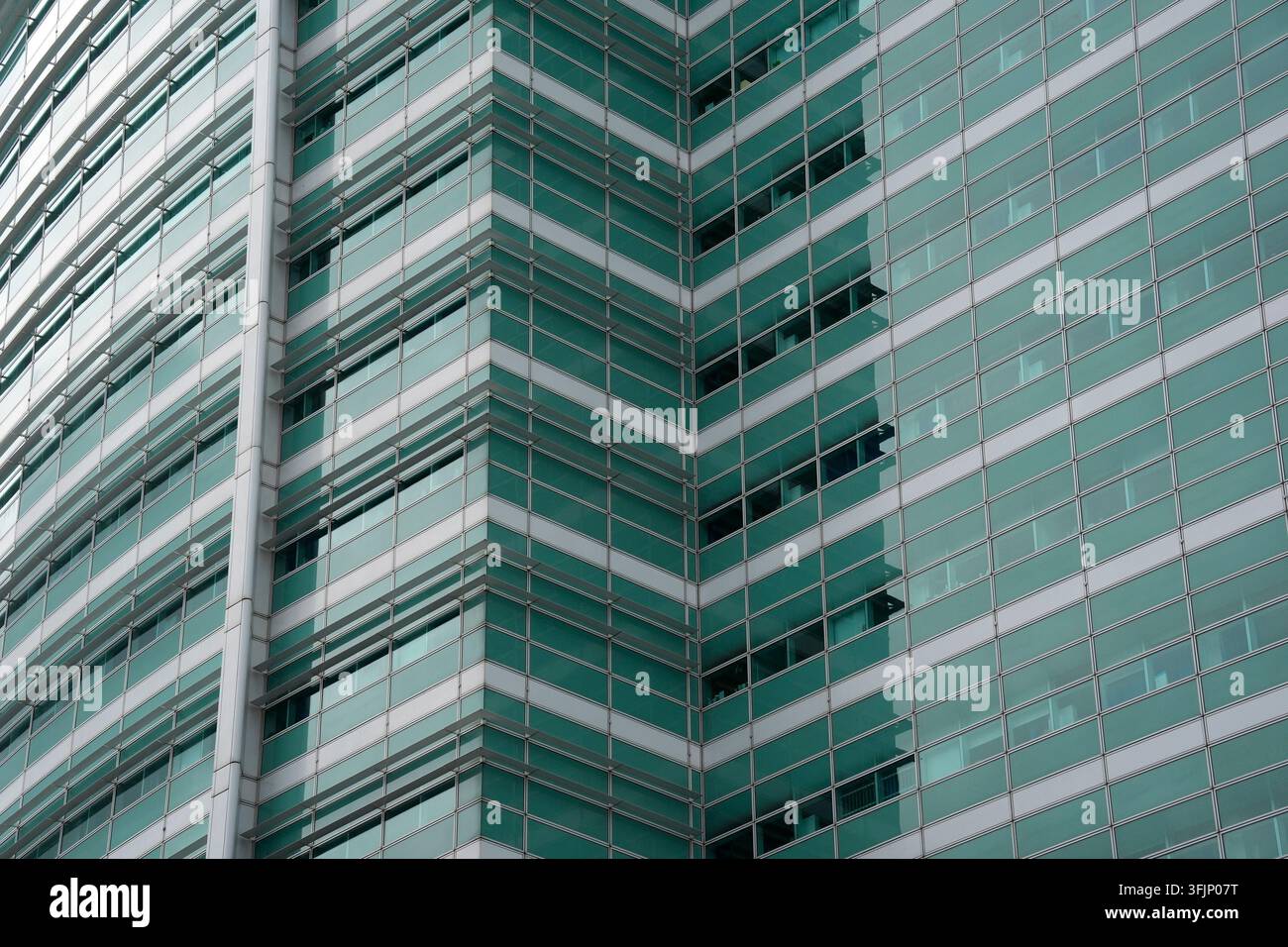 Nahaufnahme eines architektonischen Details einer zeitgenössischen Glas- und Stahl-Fassade mit blaugrünen Fenstern in London. Stockfoto