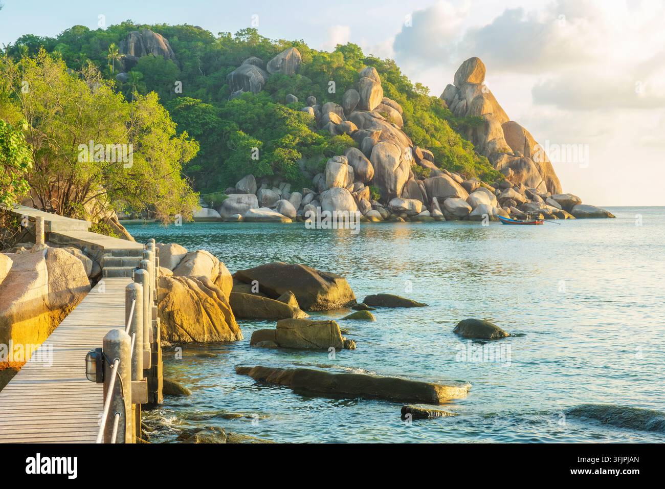 Holziger Küstensteg führt an Granitfelsen und ruhigem tropischen Meer in der Nähe von Freedom Beach auf Koh Tao, Thailand. Küstenreisen, Freizeitaktivitäten im Freien Stockfoto