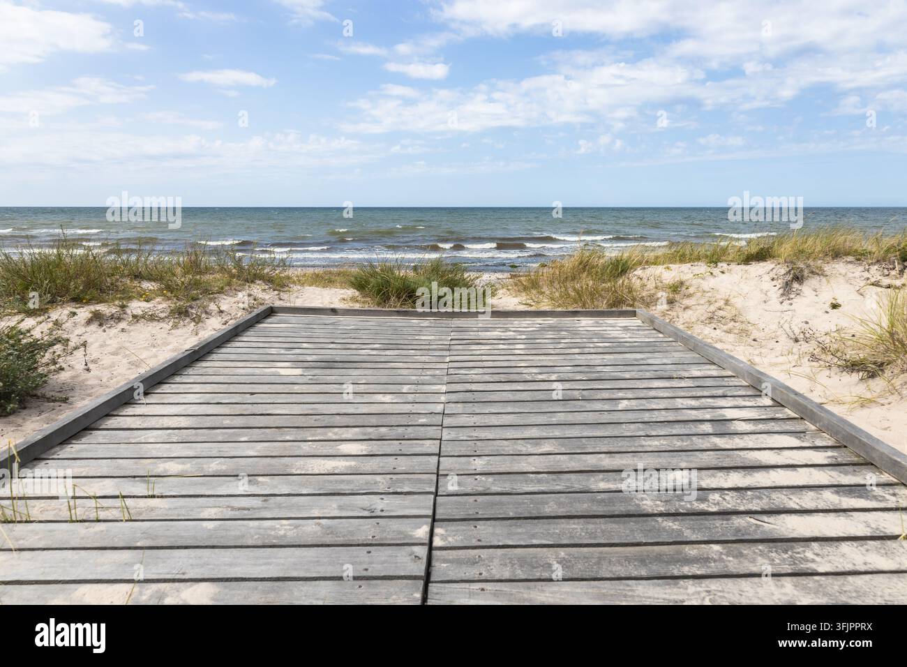 Holzsteg, der zum Sandstrand und zum Meer führt Stockfoto