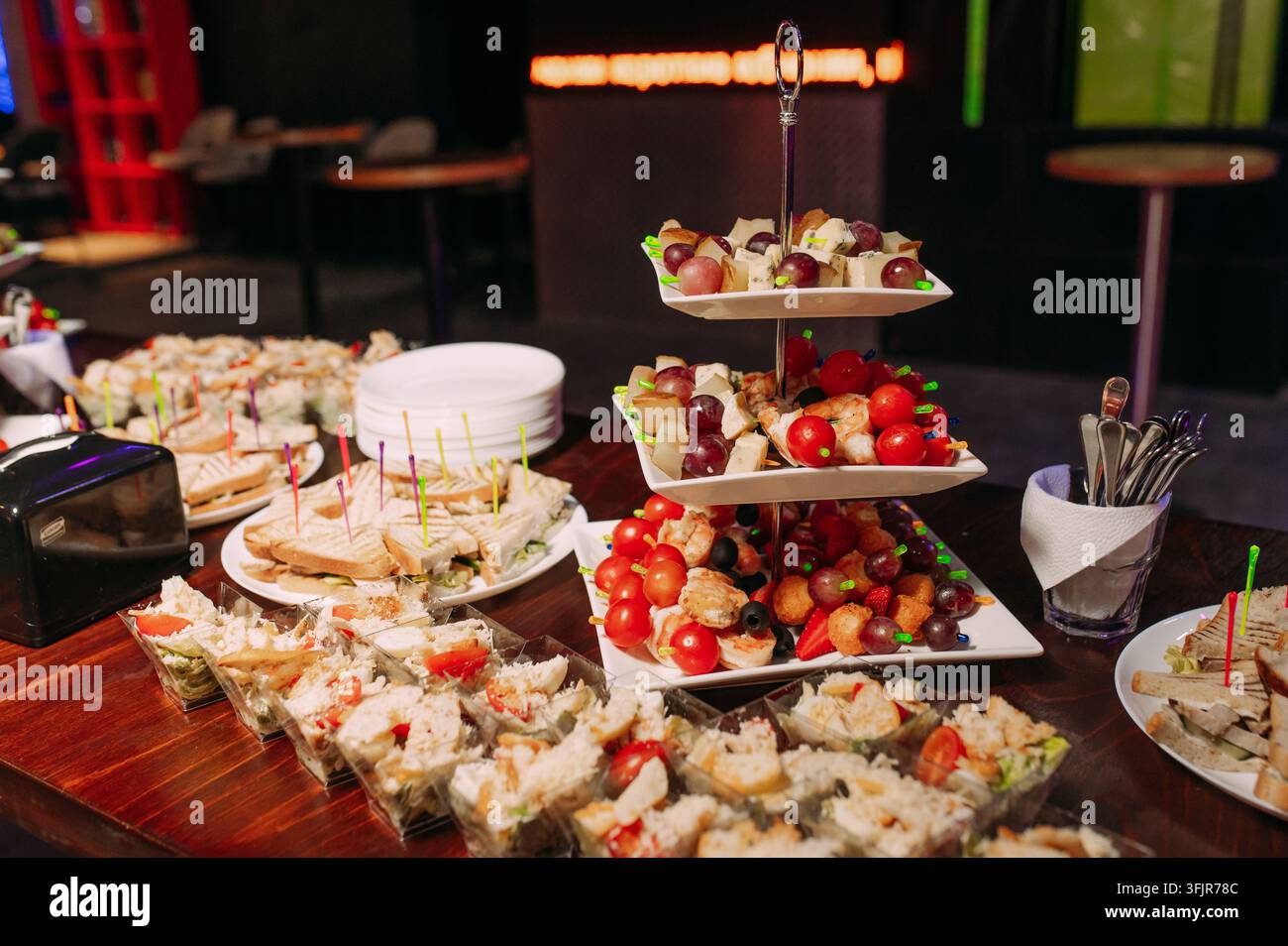 Catering-Buffet mit verschiedenen Finger-Food-Sandwiches, Obst und Vorspeisen bei einer festlichen Veranstaltung Stockfoto