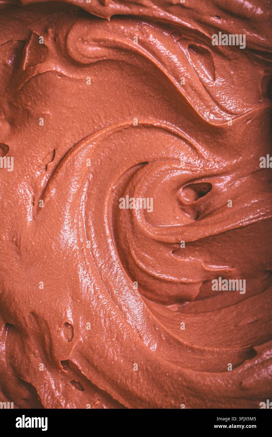 Nahaufnahme-Makroaufnahme der glatten, cremigen Schokoladenmousse-Textur mit wirbelnden Mustern und Spitzen Stockfoto