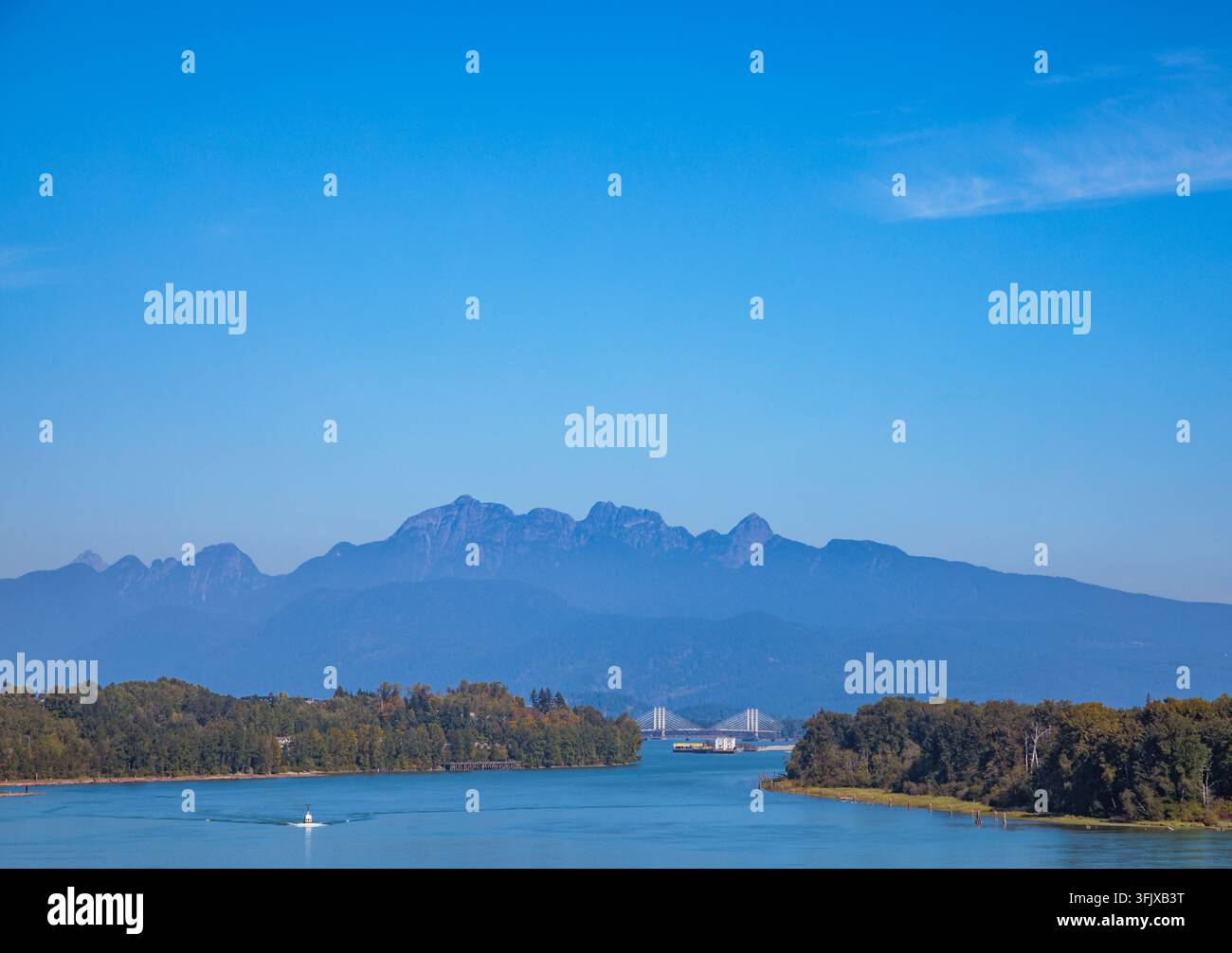 Panoramatische Aussicht mit Blick auf den Fraser River in Richtung der fernen Golden Ears Bridge und eines Berggipfels, eingerahmt von Inseln von der Port Mann Bridge Surrey BC Kanada. Stockfoto